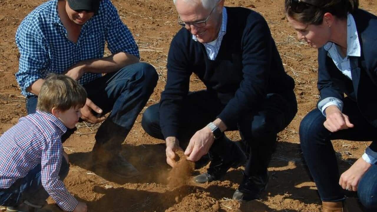 Prime Minister Malcolm Turnbull speaks with a farmer and his family