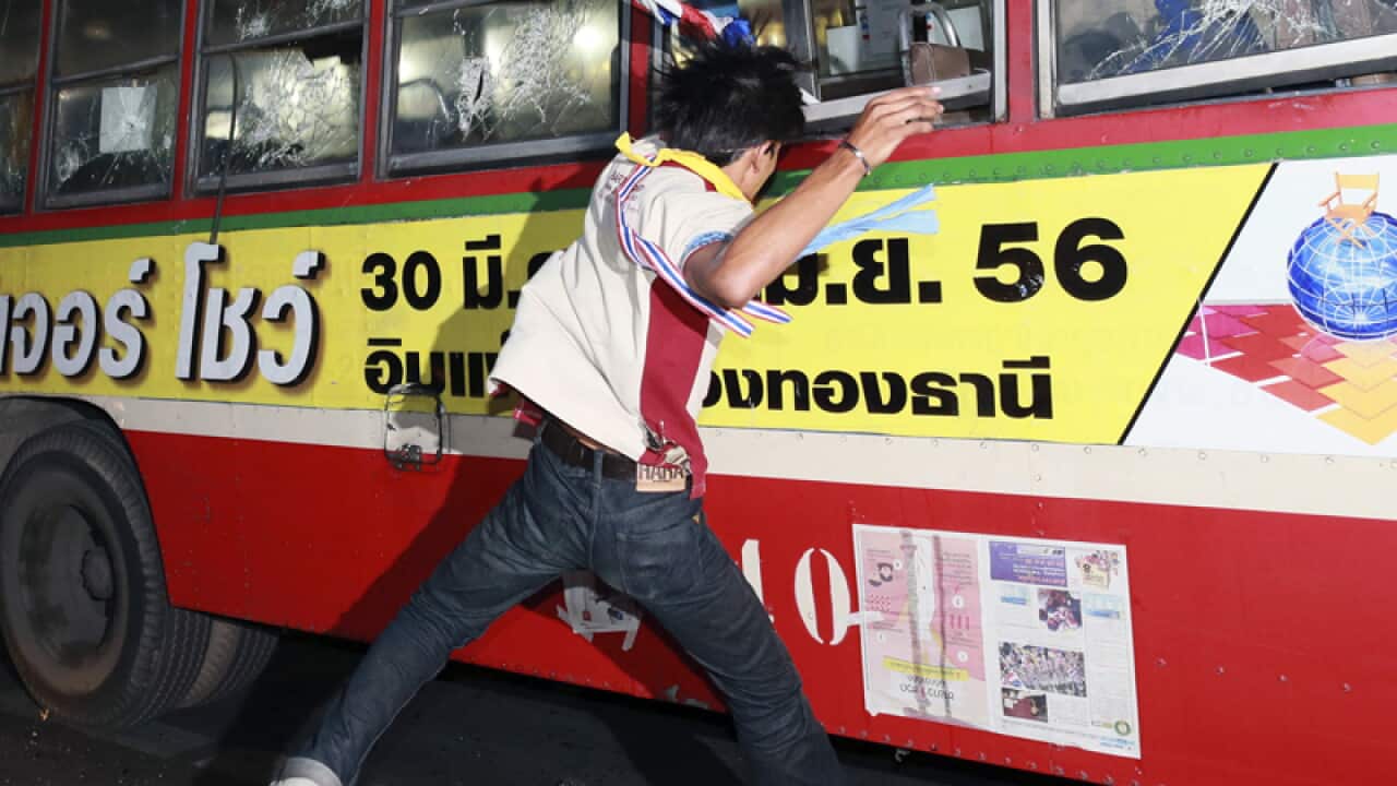 An anti-government protester attacks Thai government supporter's bus