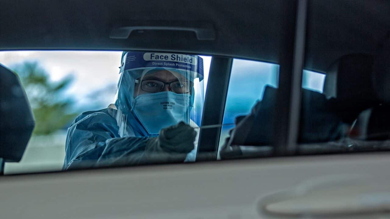 Malaysian Health official tests a driver at a drive through COVID-19 testing site at a KPJ Ampang Puteri hospital in Kuala Lumpur.