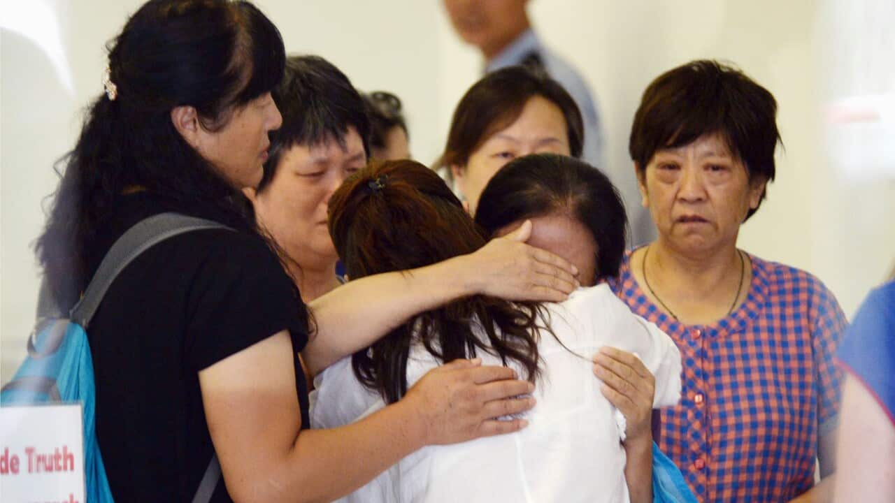 About a dozen Chinese family members and relatives of victims aboard Malaysian Airlines flight MH370, which went missing in March last year, gather in the lobby of the airline's office in Beijing on Aug. 6, 2015, to protest. (Kyodo)==Kyodo