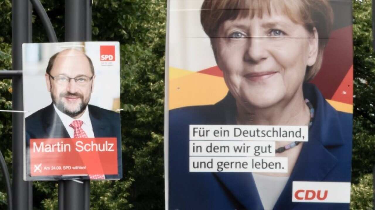 German Chancellor Angela Merkel and her challenger Martin Schulz are pictured on campaign posters in Berlin, 06 August 2017.