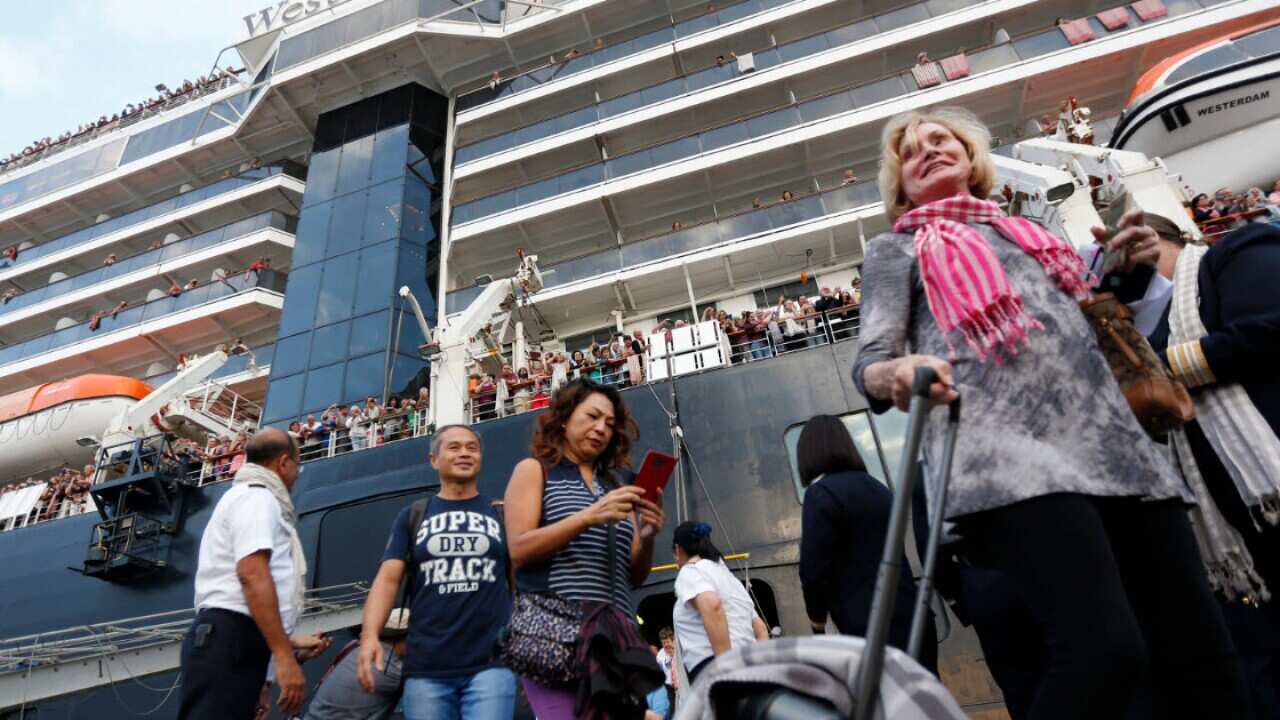 Passengers depart the MS Westerdam cruise ship at a seaport in Preah Sihanouk province, Cambodia, 14 February 2020.