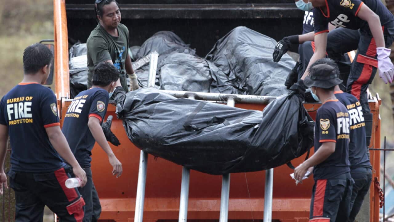 Filipino firemen unload body bags in the typhoon-hit city of Tacloban