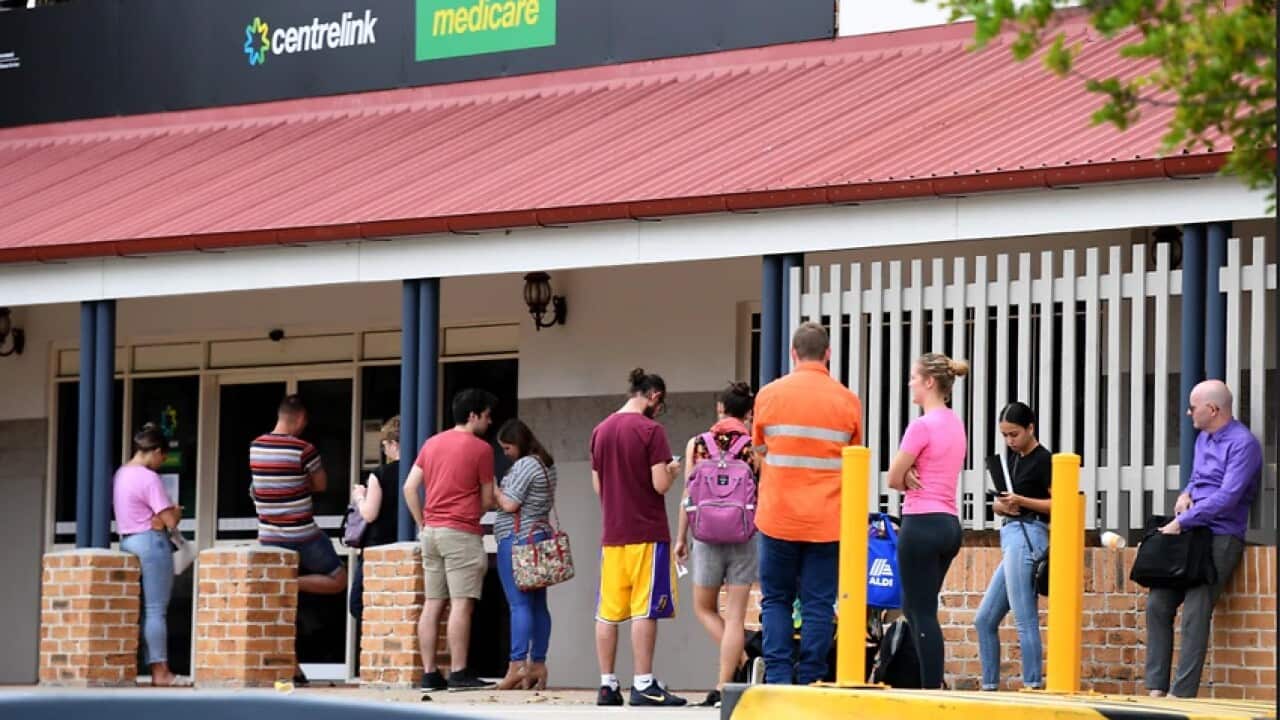 People in a long queue outside a Centrelink office in Brisbane.