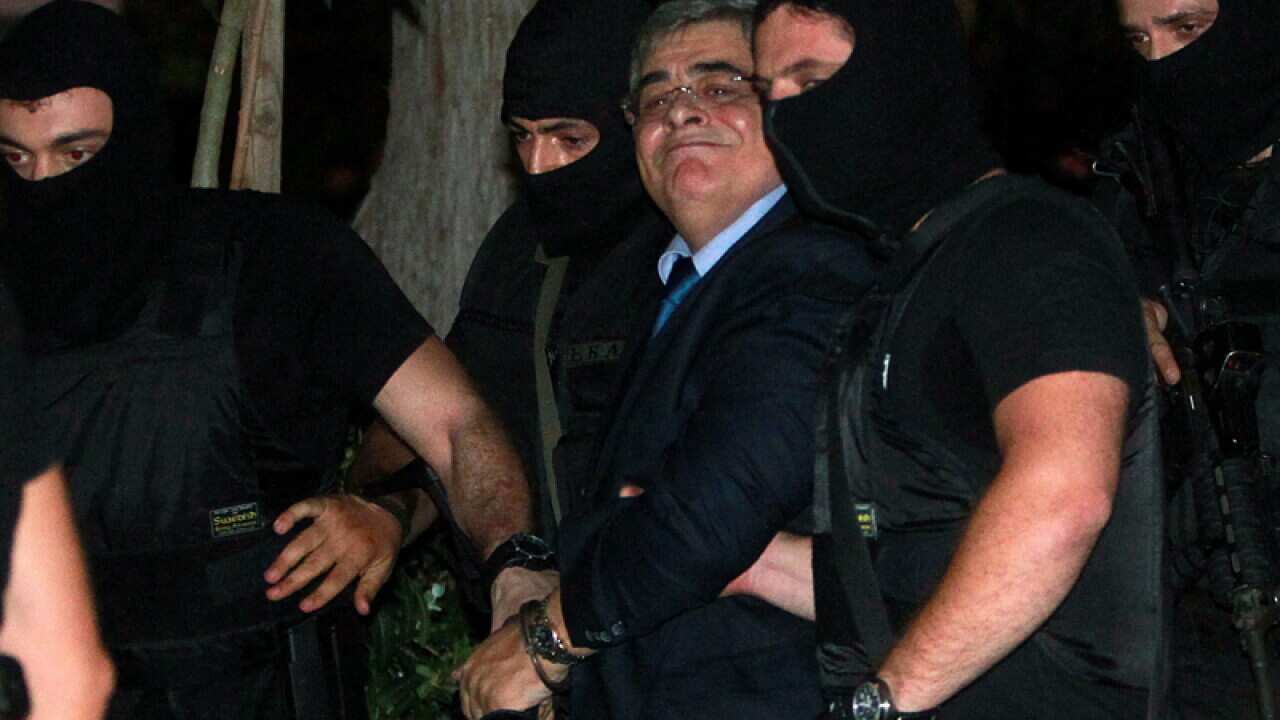 Nikos Michaloliakos is escorted at the courthouse on Wednesday
