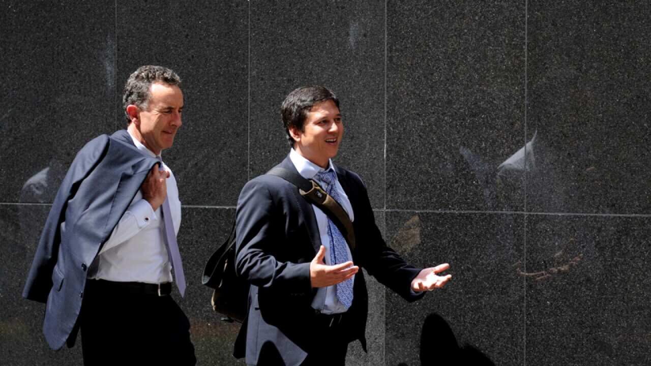 Pedestrians walk past the Reserve Bank of Australia