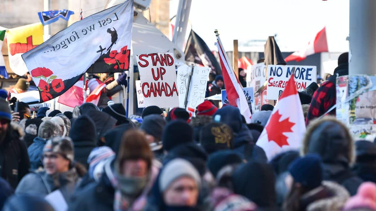 Protesters hold signs condemning the vaccine mandates imposed by Canadian Prime Minister Justin Trudeau in Ottawa, Canada