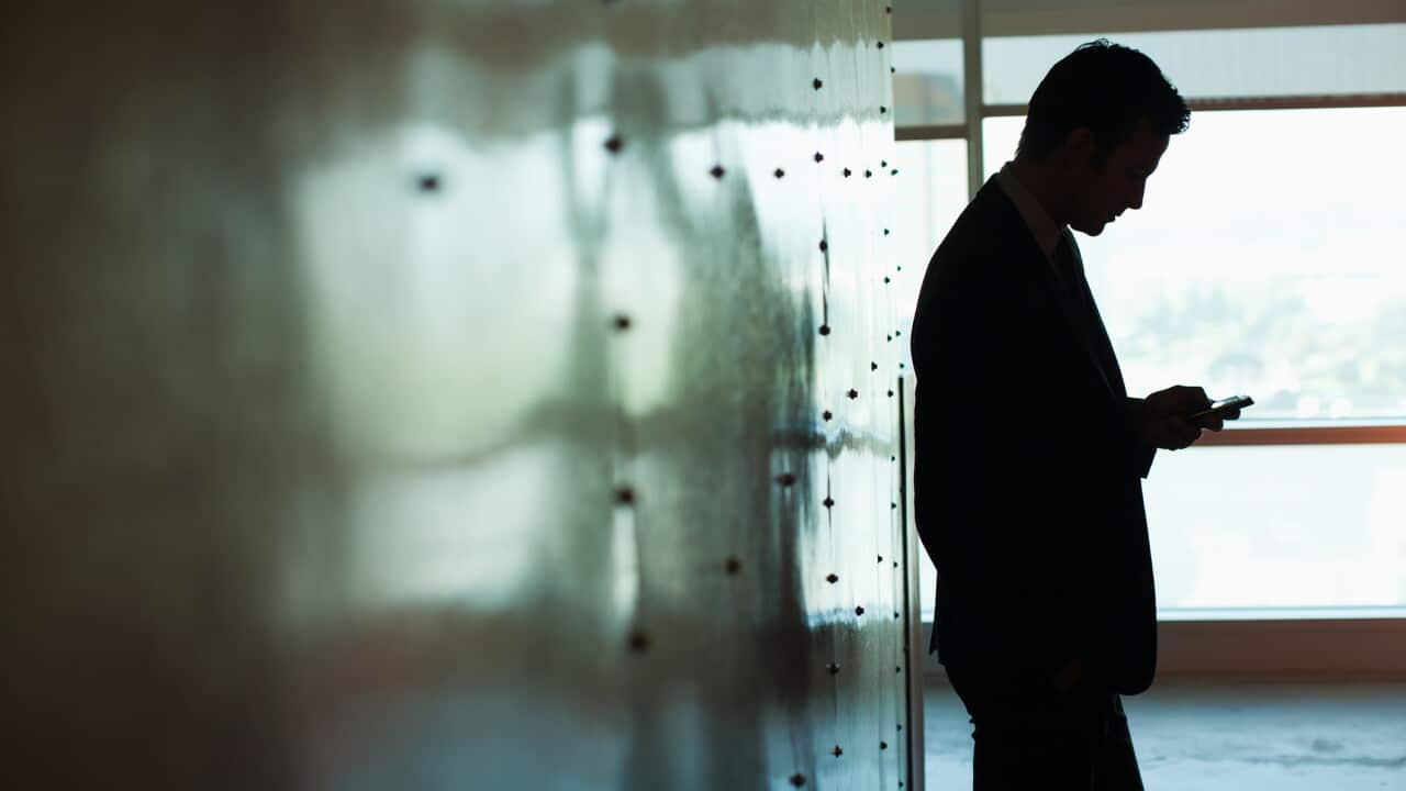 Silhouette of businessman using cell phone