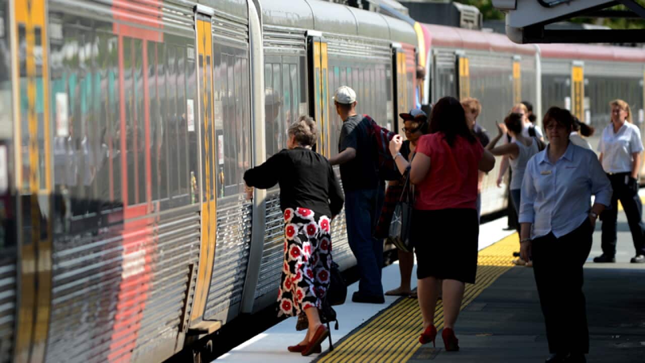 Passengers board a Queensland Rail (QR) train in Brisbane