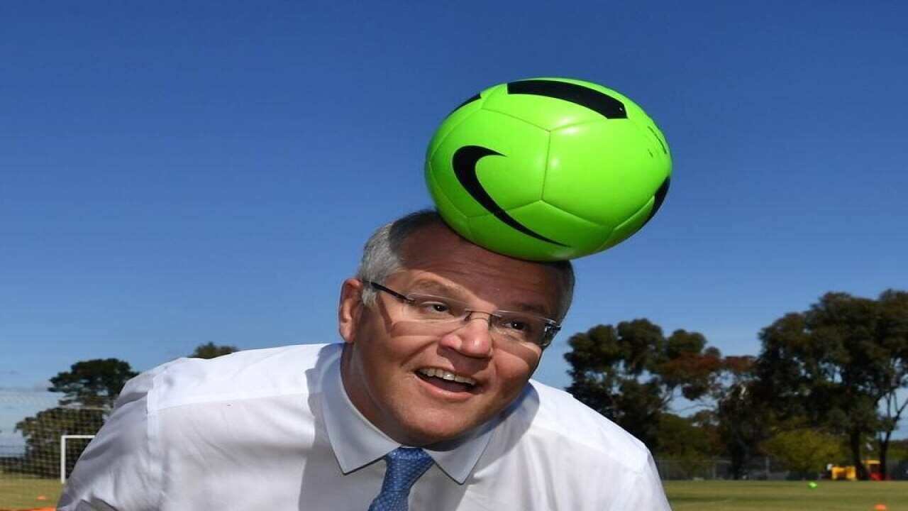 Prime Minister Scott Morrison heads a soccer ball in Adelaide.