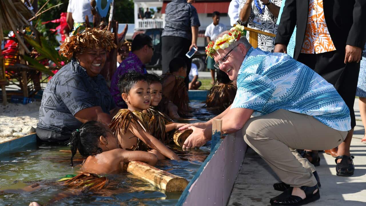 Children symbollically represent climate change greet Prime Minister Scott Morrison as he arrives for the Pacific Islands Forum in Funafuti, Tuvalu.