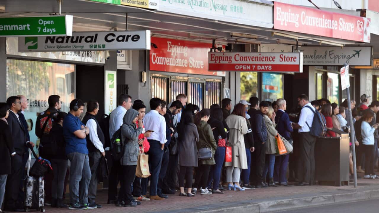 Commuters wait for buses at Epping train station in Sydney.