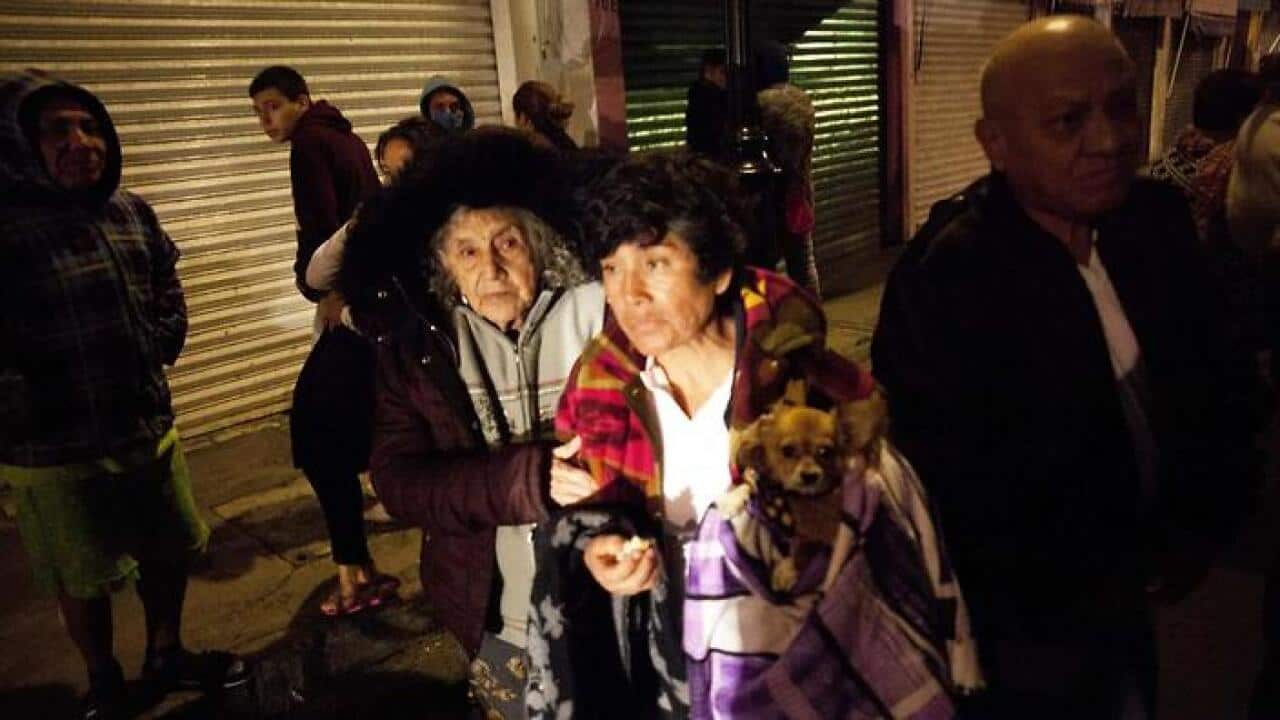 People gather on a street in the Tlatelolco neigborhood of Mexico City during an earthquake on September 7, 2017