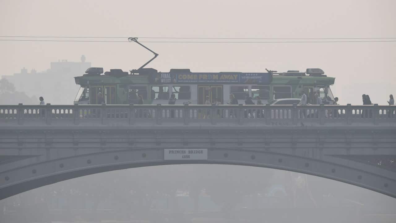Morning commuters are seen through smoke haze from bushfires in Melbourne.