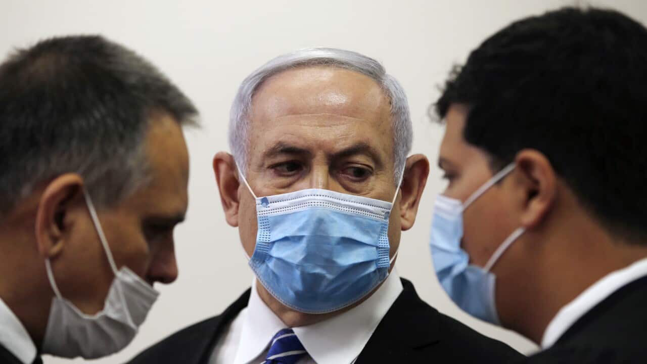 Israeli Prime Minister Benjamin Netanyahu standing inside the court room as his corruption trial opens at the Jerusalem District Court