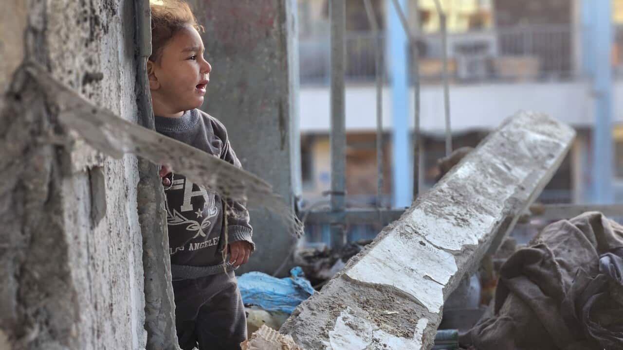 A Palestinian child in the ruins following an airstrike on a school turned shelter in Gaza