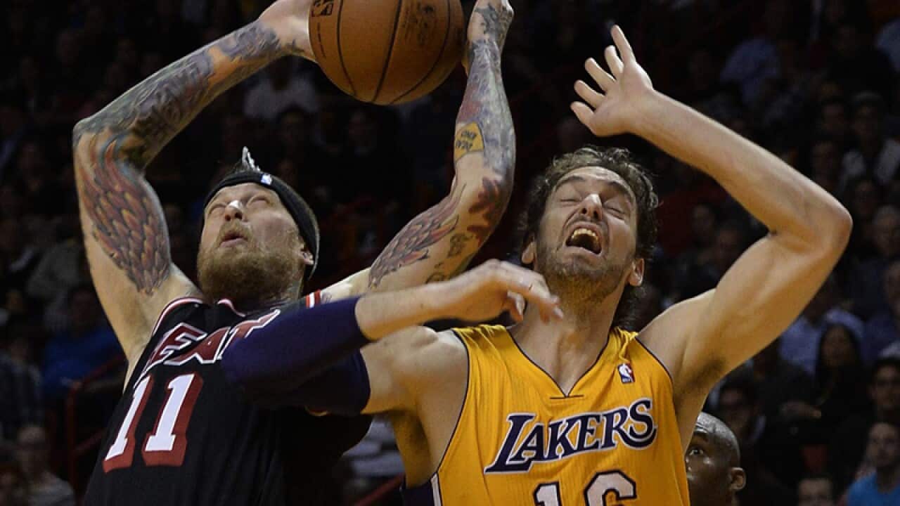 Chris Andersen (L) and Pau Gasol vie for the ball