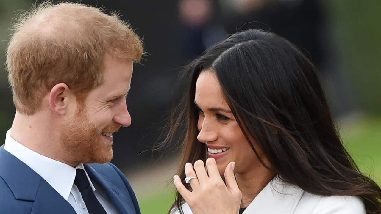 Britain's Prince Harry (L) poses with his fiancee, US actress Meghan Markle during a photocall after announcing their engagement in the Sunken Garden