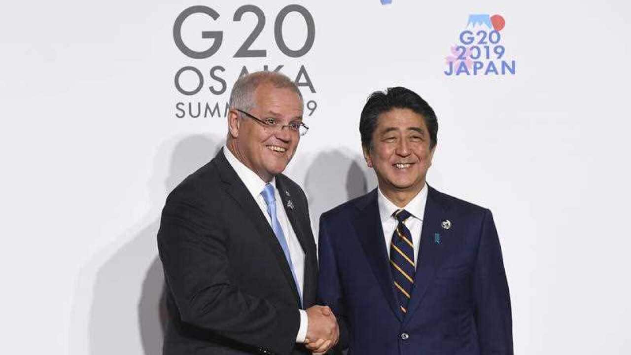 Prime Minister Scott Morrison shakes hands with Prime Minister of Japan Shinzo Abe during the Leaders Welcome at the G20 summit in Osaka, Japan
