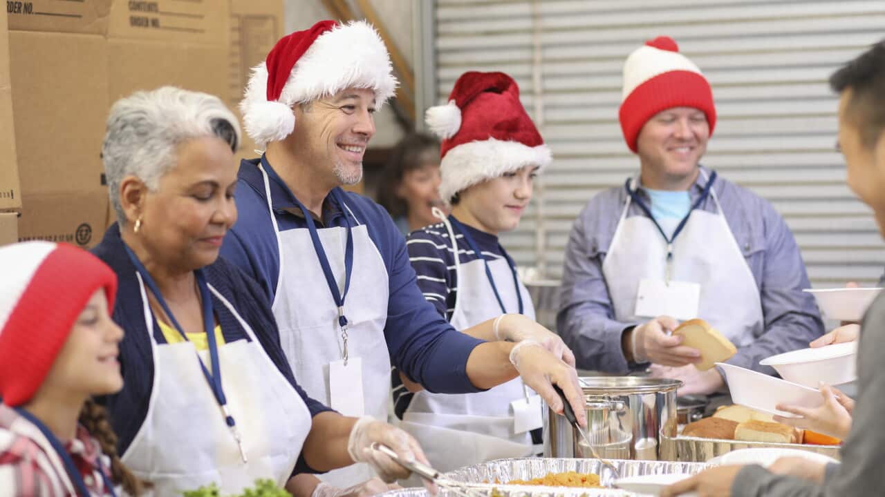 Multi-ethnic volunteers serves food at soup kitchen at Christmas.