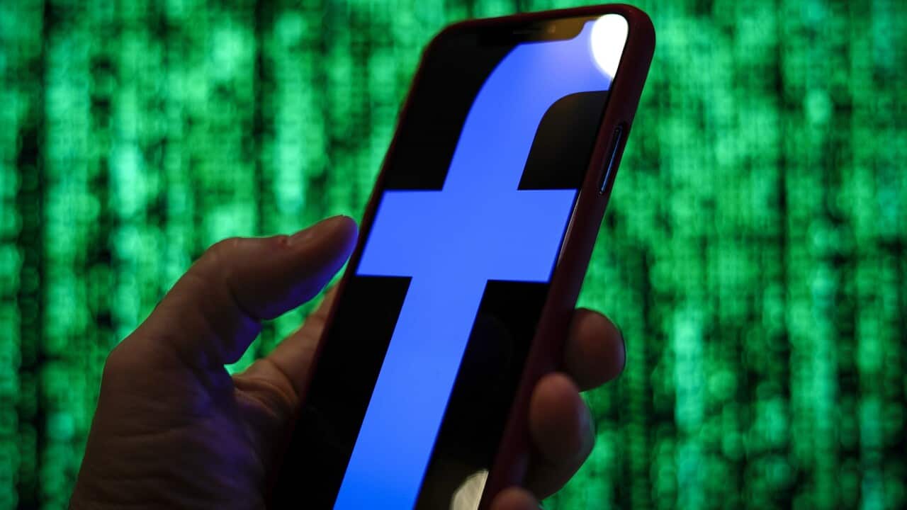 The Facebook logo is seen displayed on a mobile device in front of a screen with data in this photo illustration in Warsaw, Poland.