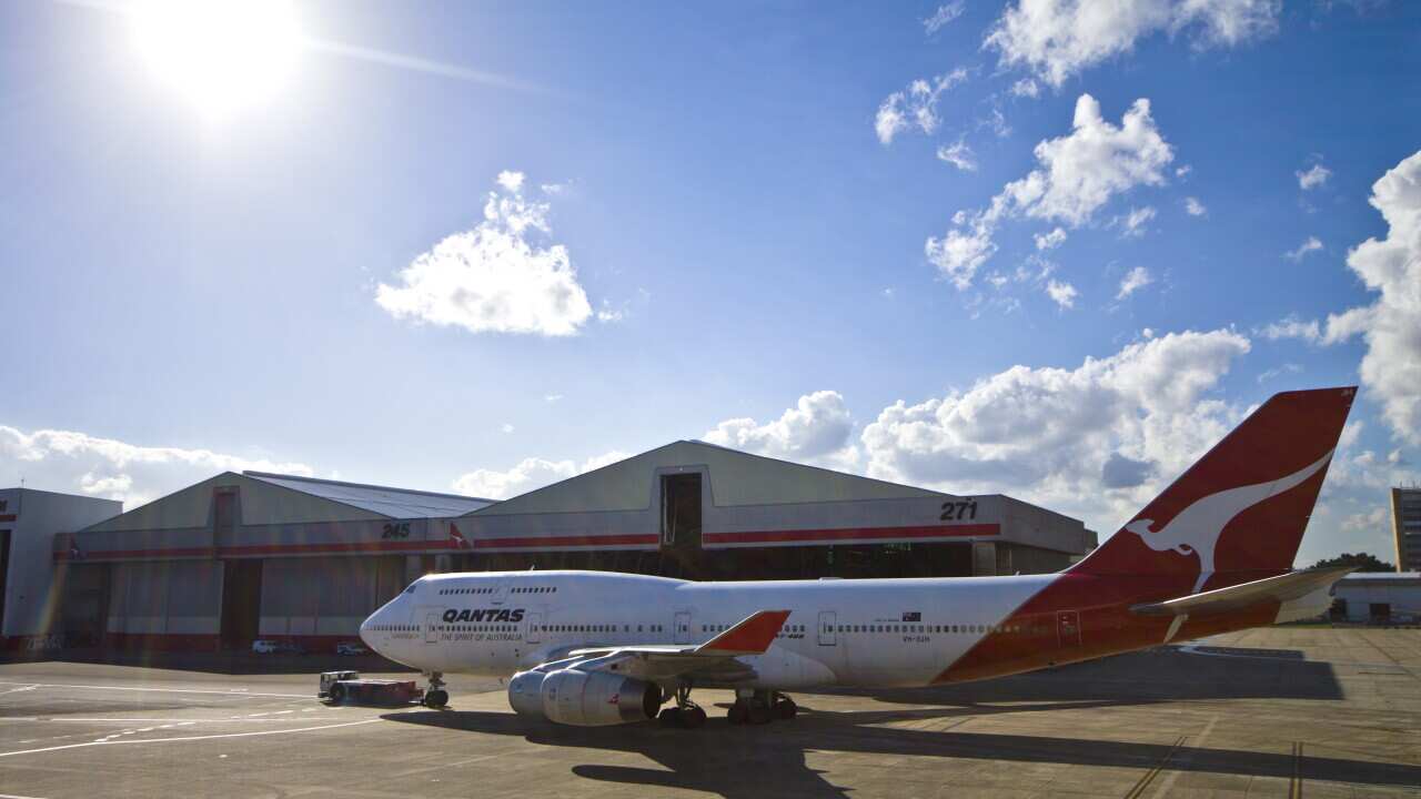 A tractor known as an airplane tug tows a plane across the tarmac.