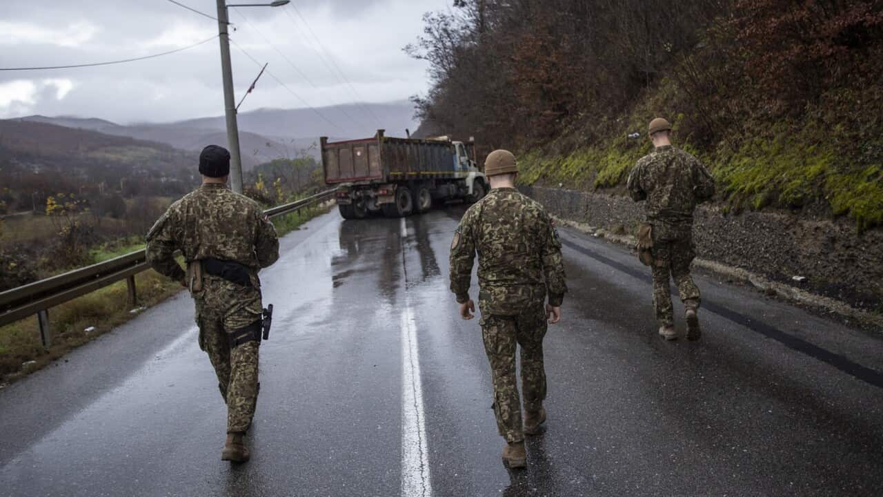 NATO led Latvian soldiers head to inspect trucks at a roadblock at a border crossing point (Getty)