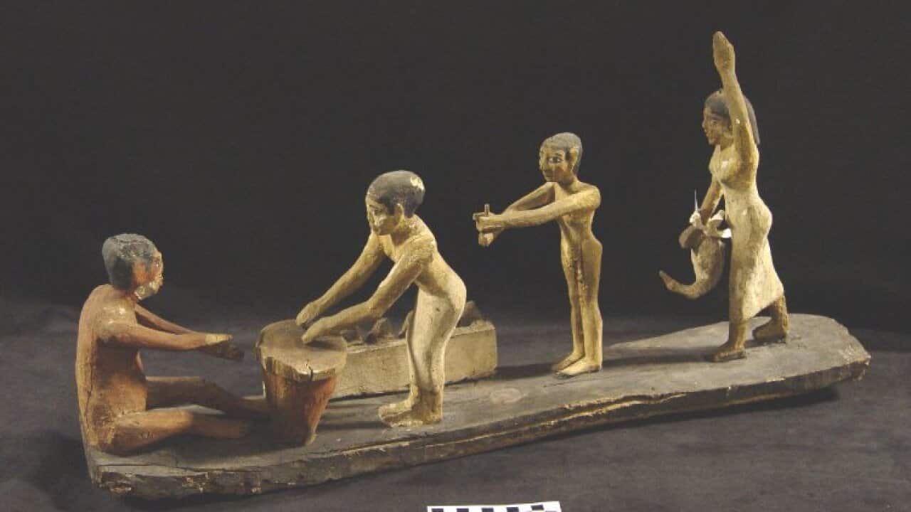 Painted wooden model group: four figures preparing food and beer. 6th Dynasty, Sidmant, Egypt.