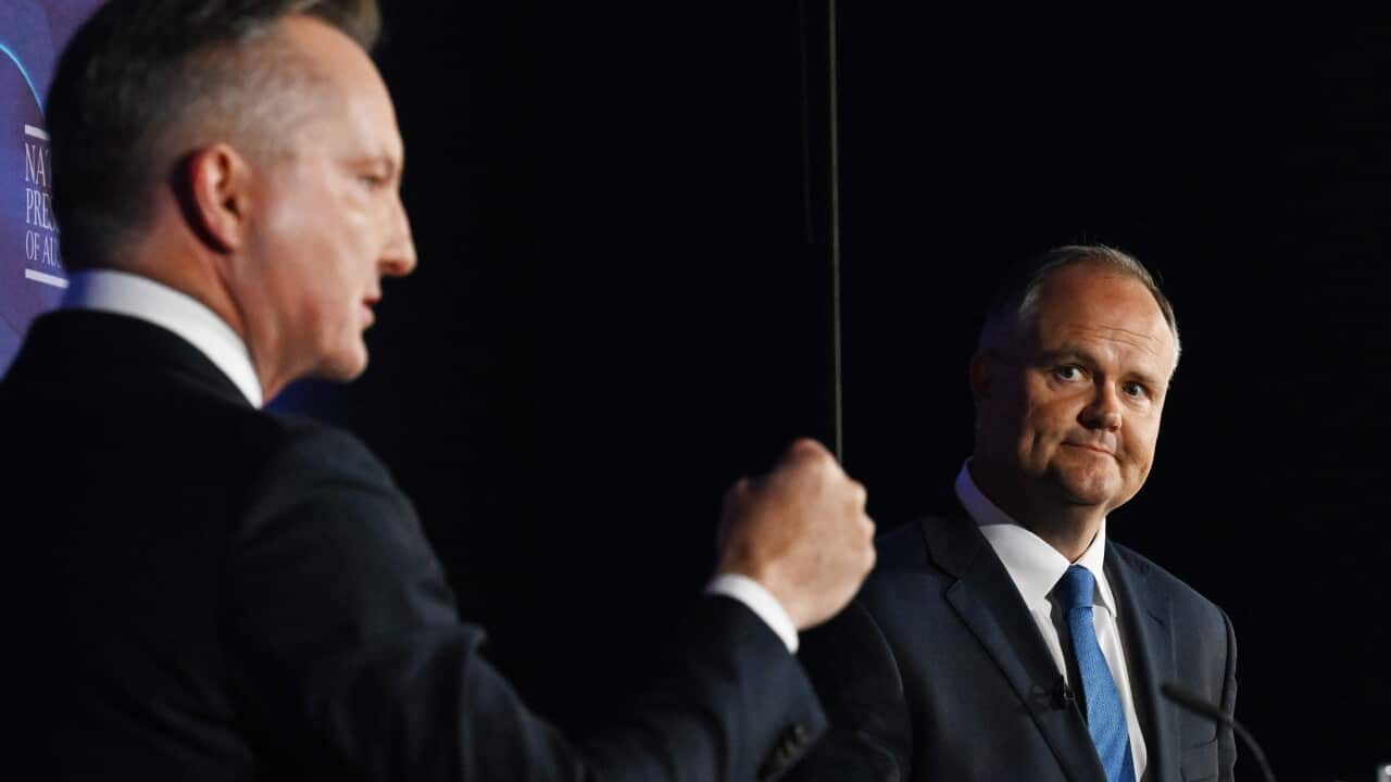 Two men in suits are standing next to each other.