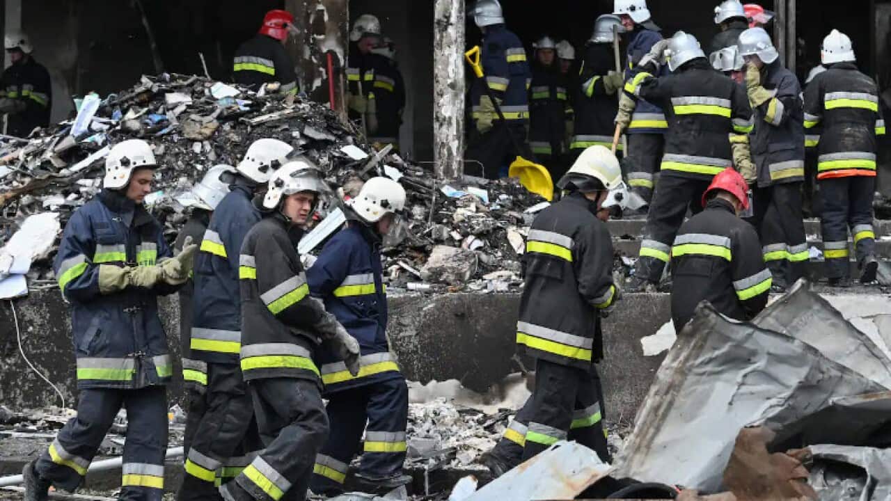 Firefighters gather as they take rubbles out of a damaged building following a Russian airstrike in the city of Vinnytsia, west-central Ukraine, on July 14, 2022.