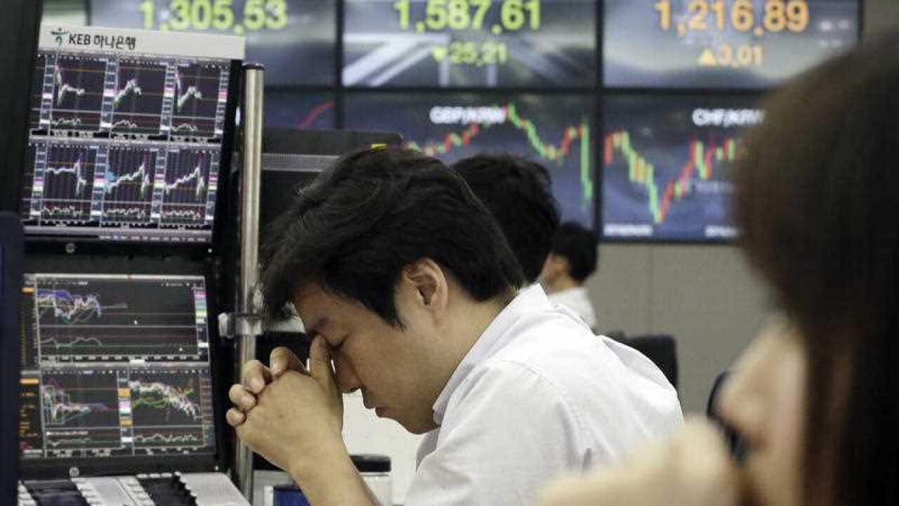 A currency trader rubs his eyes at the foreign exchange dealing room of the KEB Hana Bank headquarters in Seoul, South Korea