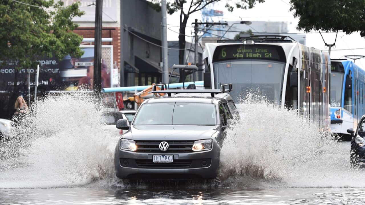 Cars and trams drive through floodwaters in Melbourne