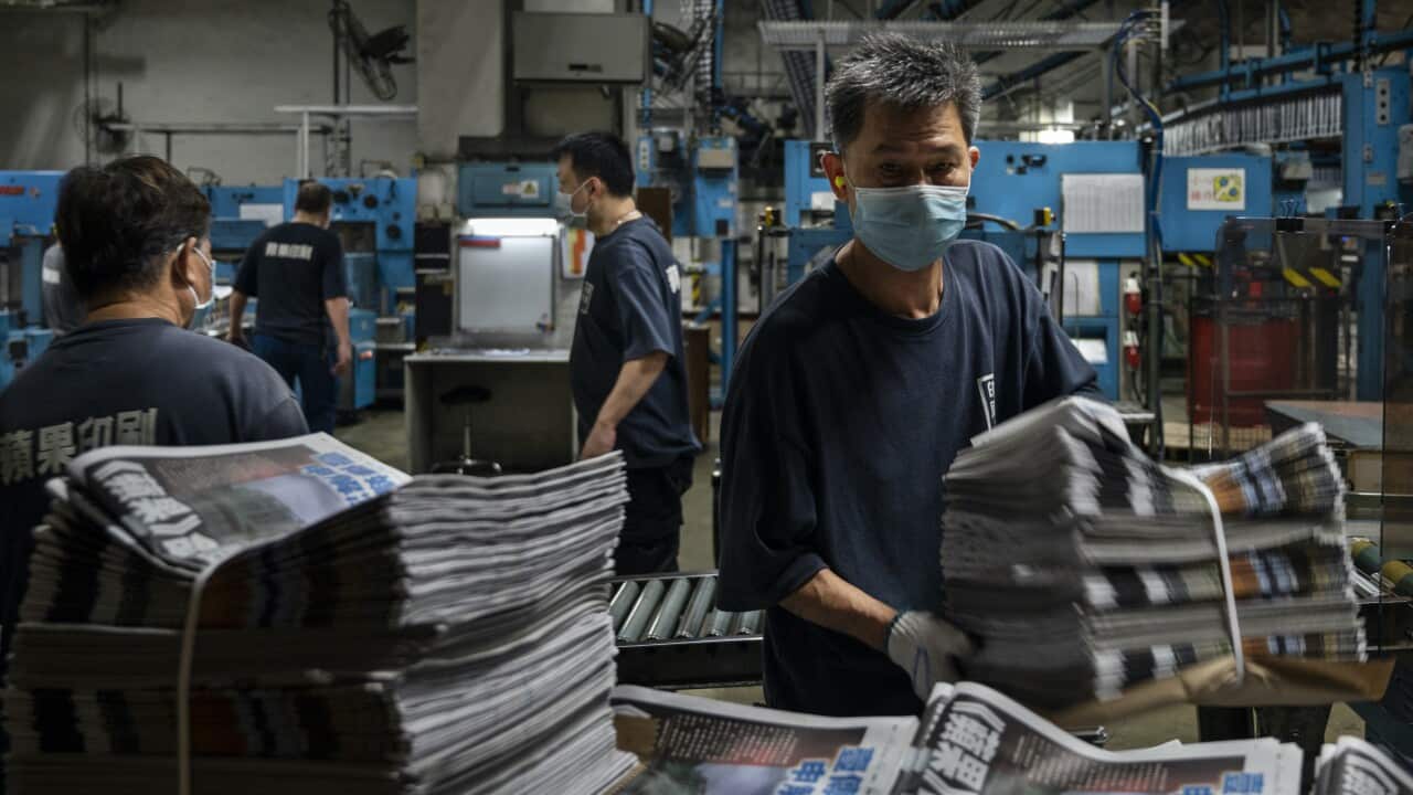 Workers pack newspapers for delivery at Apple Daily printing facility in Hong Kong on 22 June, 2021.