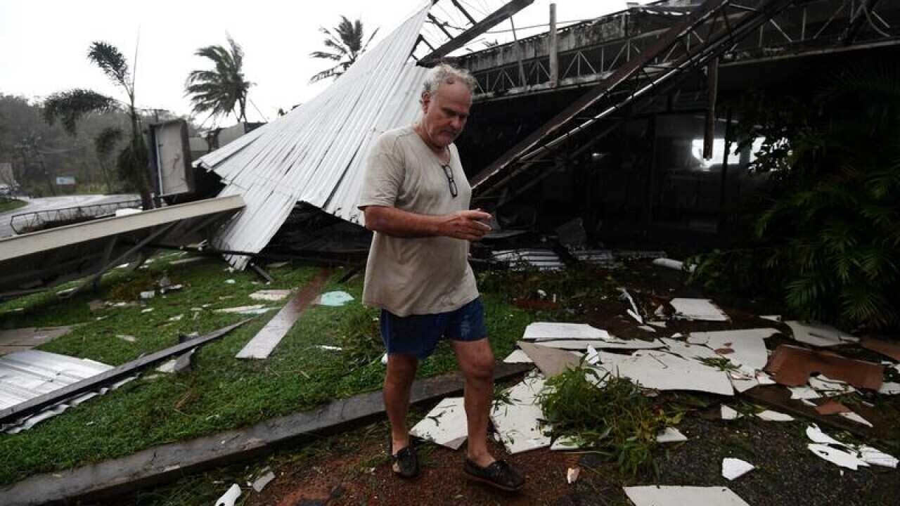 Dave Mcinnerney inspects the damage to his motel at Shute Harbour