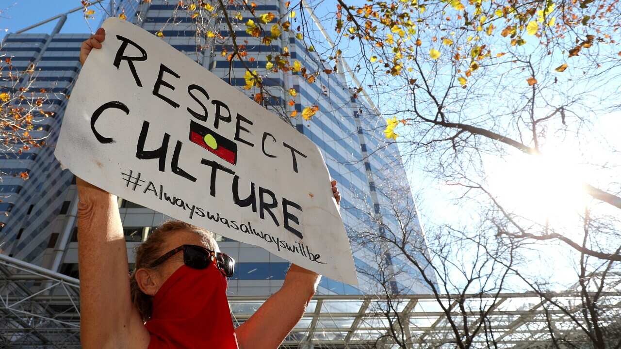 Protesters are seen during a rally outside the Rio Tinto office in Perth