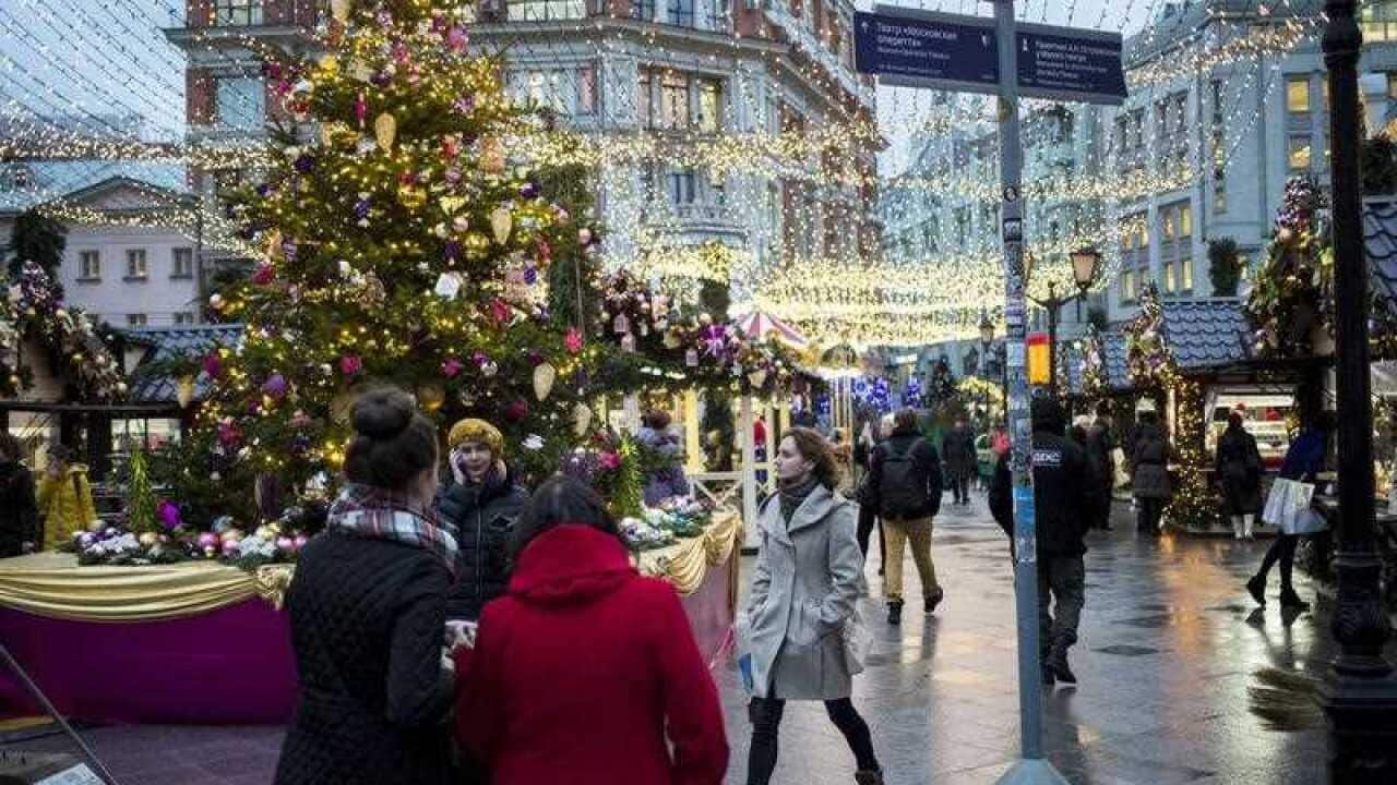 People walk on Kuznetsky Most street illuminated to celebrate the upcoming Christmas and New Year in Moscow downtown, Russia