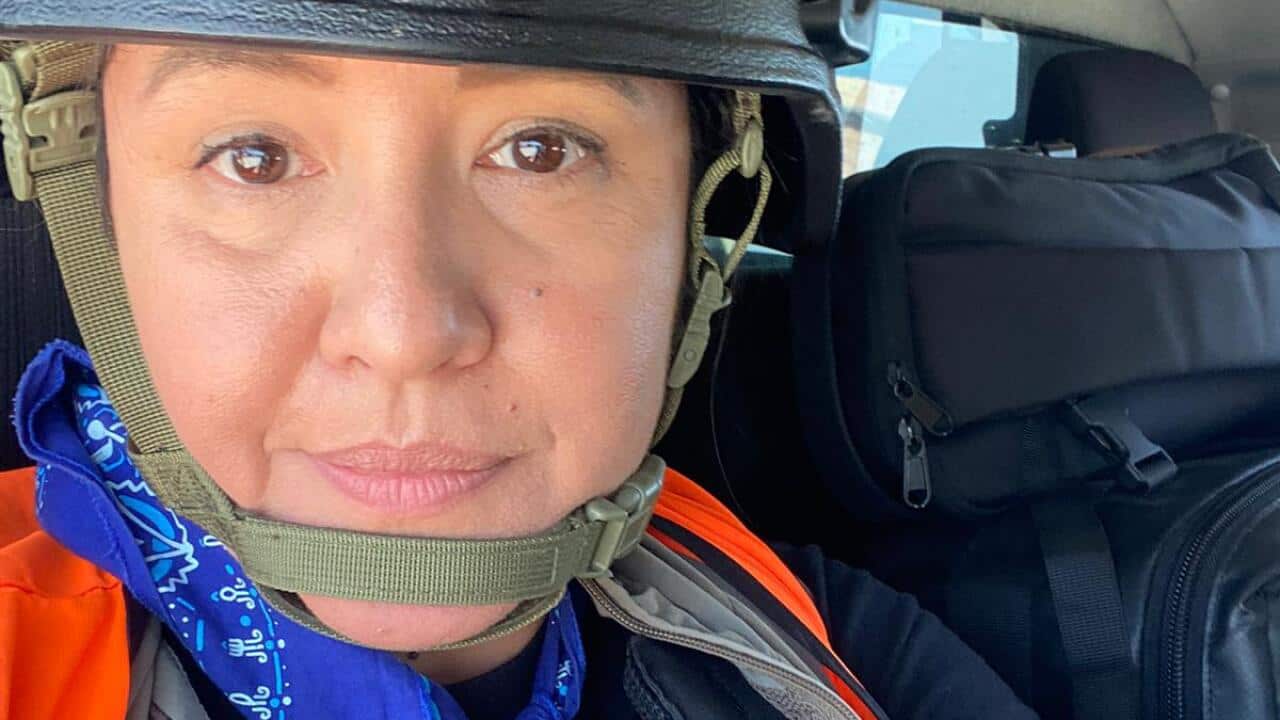 A woman wearing a helmet in a vehicle