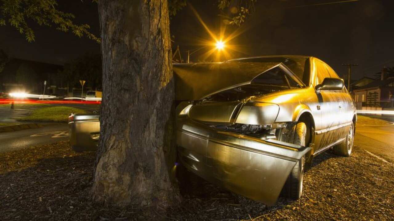 Car crashed on a tree trunk during the night