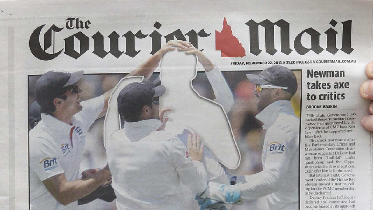 A person reads The Courier Mail newspaper