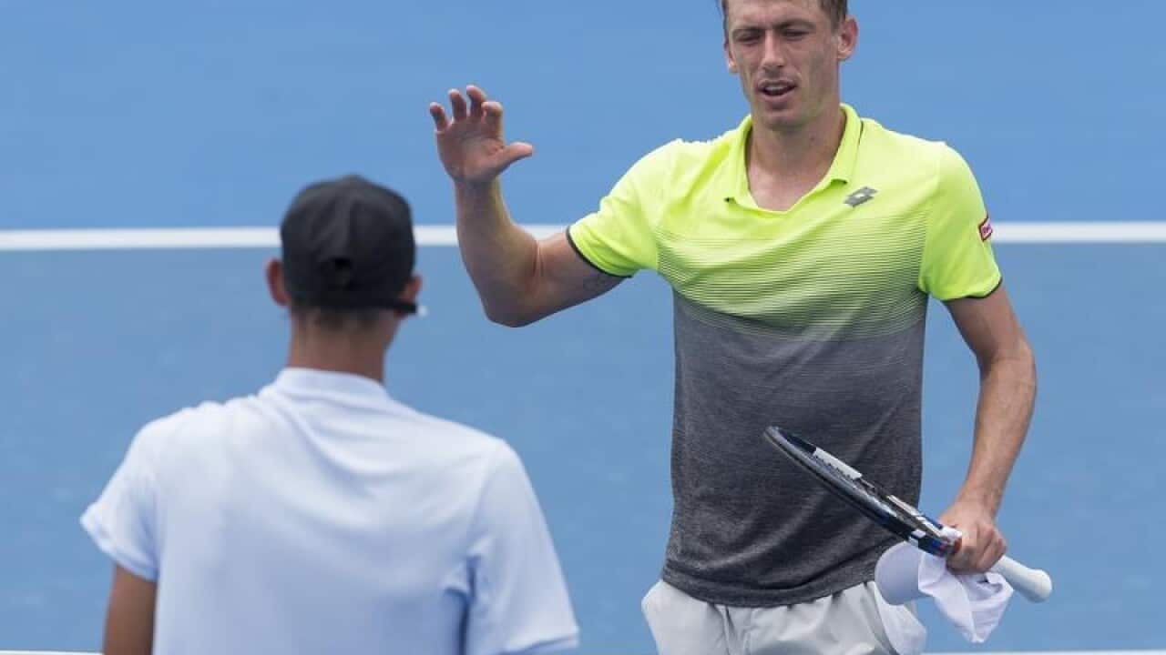 John Millman of Australia (right) defeats Alexei Popyrin of Australia.