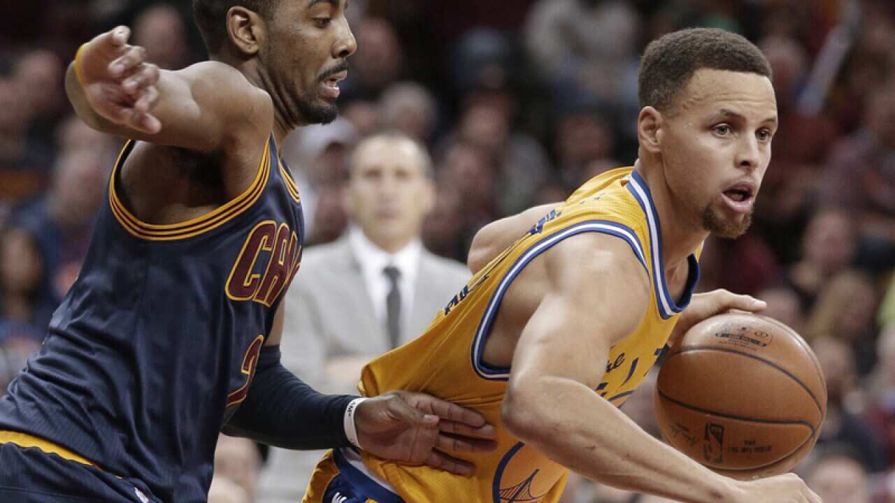 Warriors’ Stephen Curry (R) drives past Cleveland's Kyrie Irving