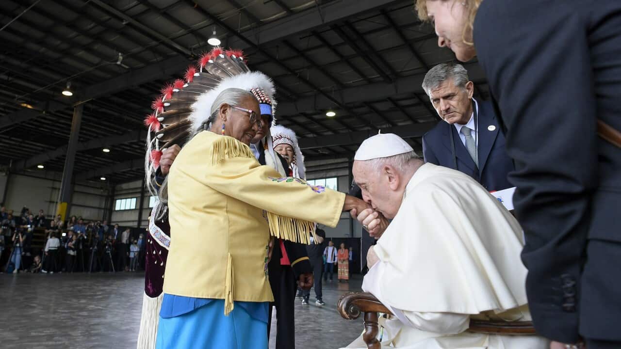 Pope Francis kisses the hand of a First Nations woman in Canada.