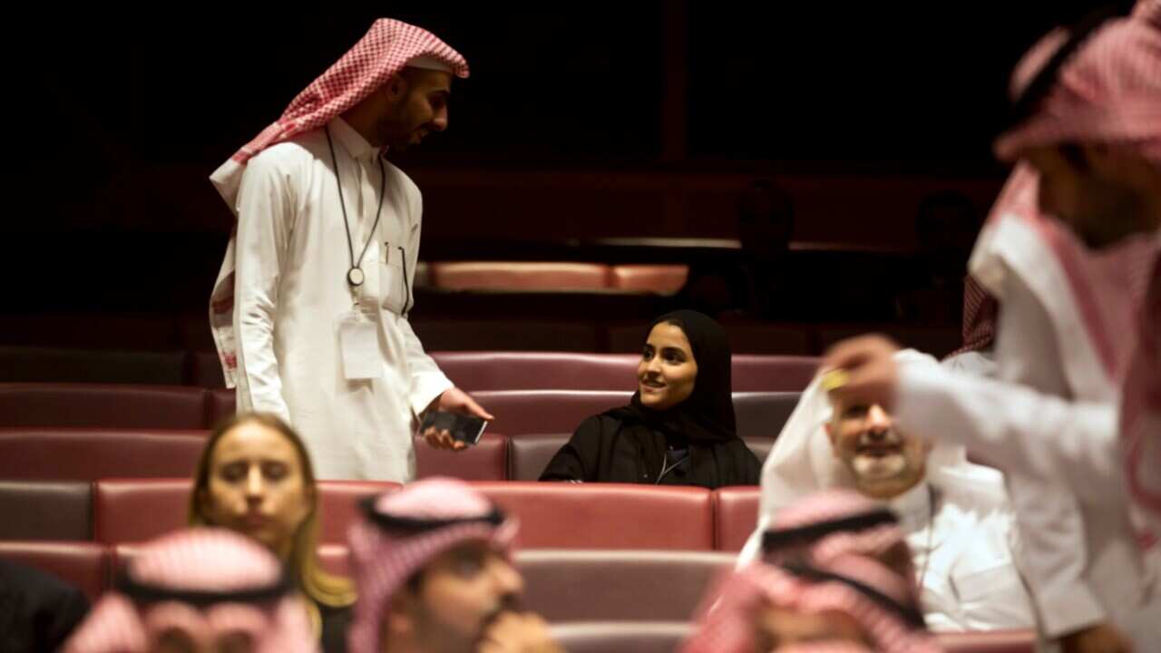 People wait for the movie to begin during an invitation-only screening, at the King Abdullah Financial District Theater, in Riyadh.