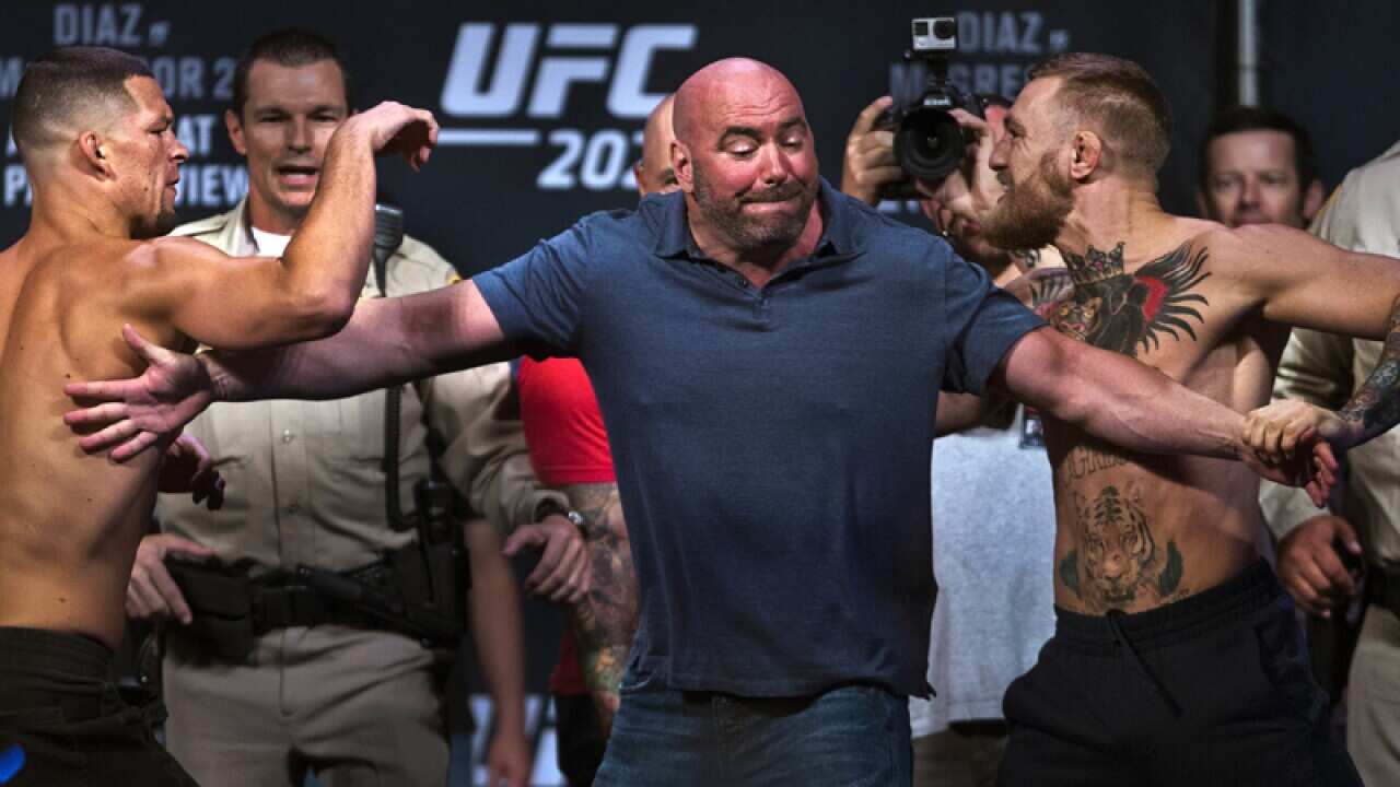 Nate Diaz, left, is held back from opponent Conor McGregor