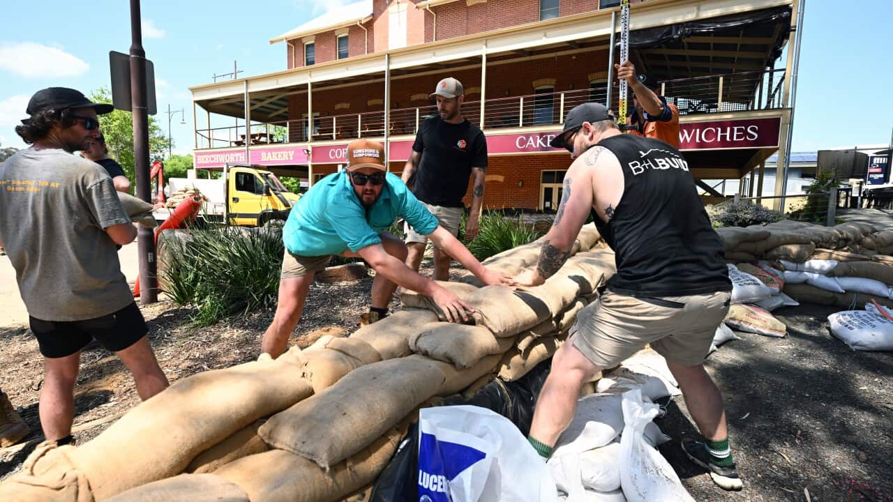 Five men make a flood levee out of sandbags