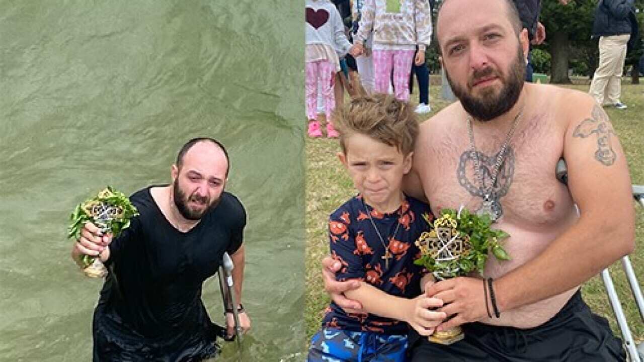 Stefan Janchevski with his son Petar cought the cross, traditionally thrown for luck by a priest every year for Epiphany in the waters of Dolls Point in Sydney