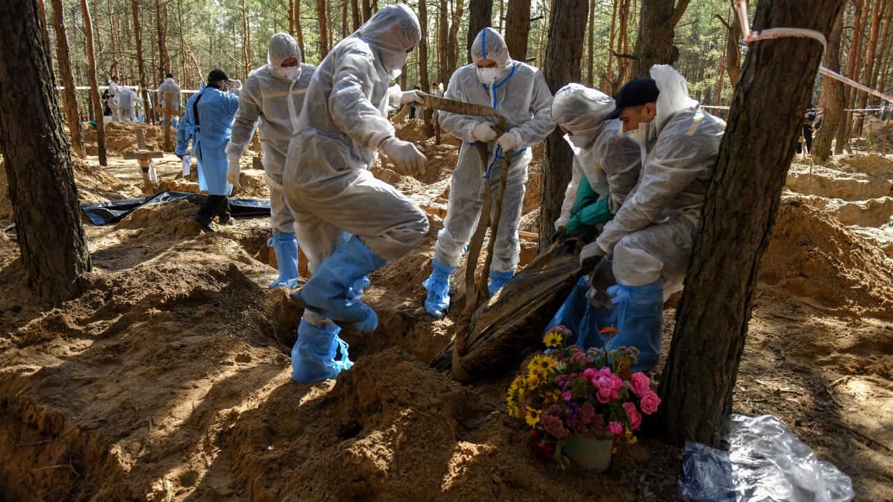 Workers move an exhumed body on the cemetery in Izyum, Kharkiv region, Ukraine on 22 September 2022.