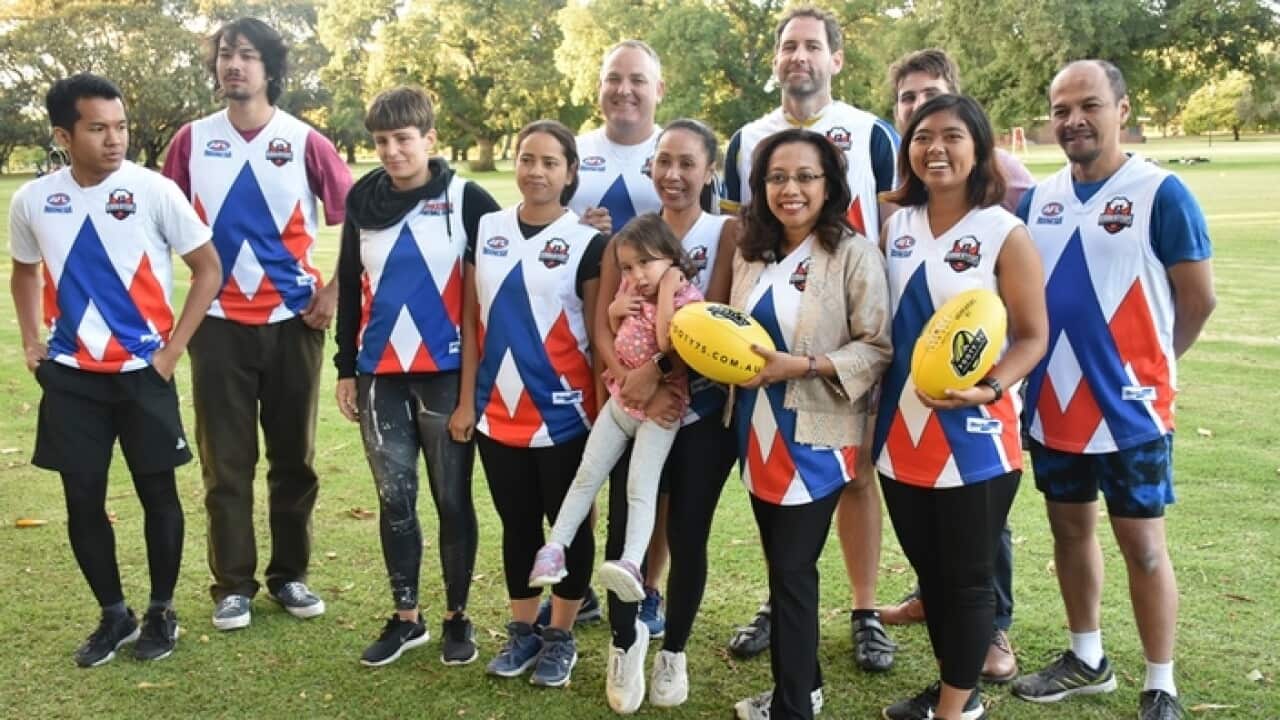 Consul General Spica Tutuhatunewa (second from right, front row) and Joel Blackwell (third from right, back row) and team mates pose for the camera.