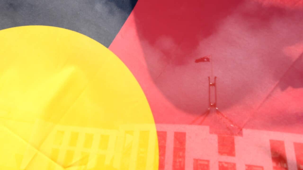 Parliament House in Canberra seen through the Aboriginal flag