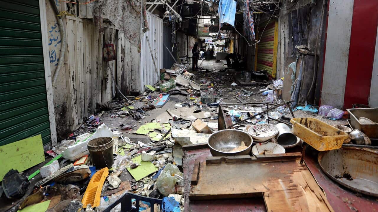 Iraqis inspect the site of a bomb attack at Sinak market in central Baghdad, Iraq